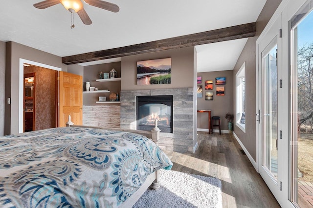 bedroom with access to exterior, baseboards, beam ceiling, a tile fireplace, and wood finished floors