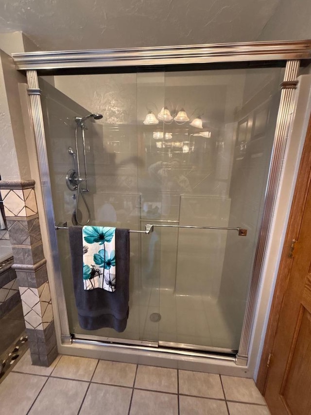 full bathroom with a shower stall and tile patterned flooring