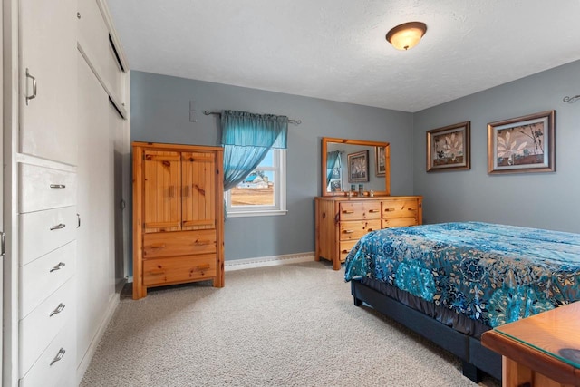 bedroom with carpet, baseboards, and a textured ceiling