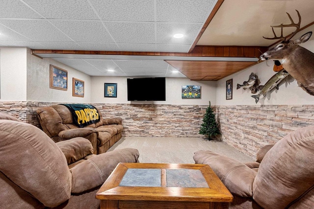 living room with a drop ceiling and wainscoting