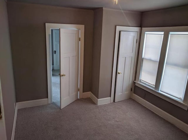 unfurnished bedroom with baseboards and carpet floors