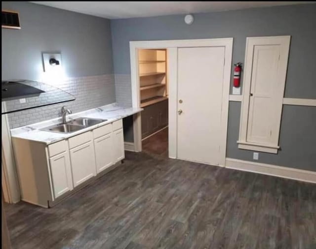 kitchen featuring tasteful backsplash, a sink, light countertops, white cabinetry, and dark wood-style flooring