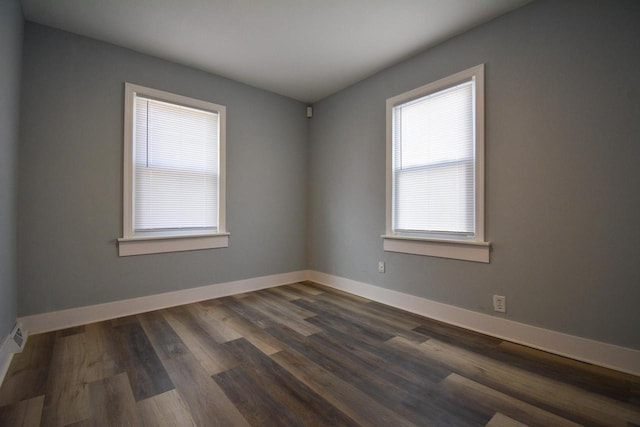 empty room with baseboards and dark wood finished floors