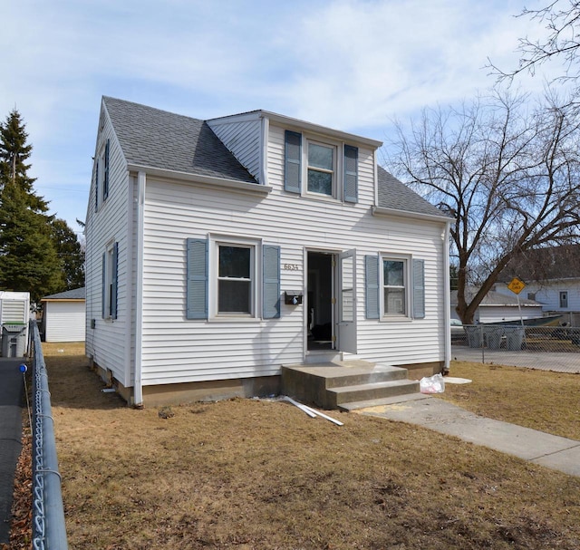 bungalow-style home with a garage, a front yard, roof with shingles, and fence