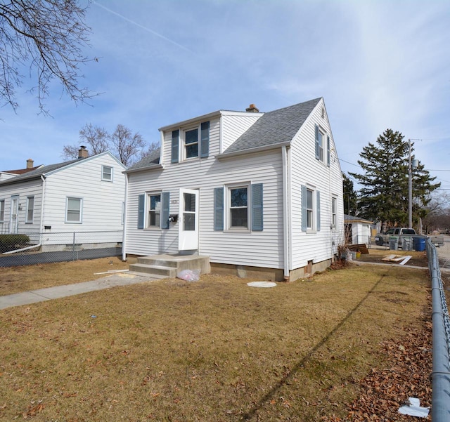 view of front of house with a shingled roof, a front yard, and fence