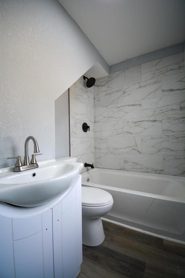 bathroom with bathtub / shower combination, vanity, toilet, and wood finished floors