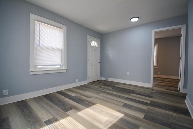 foyer featuring visible vents, baseboards, and wood finished floors