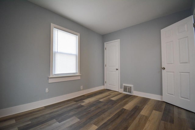 empty room with visible vents, baseboards, and wood finished floors