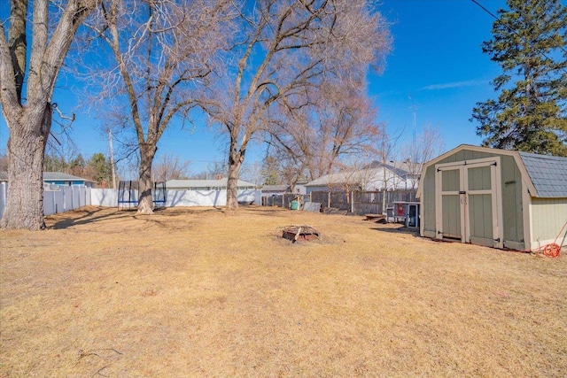 view of yard featuring a storage unit, an outbuilding, and a fenced backyard