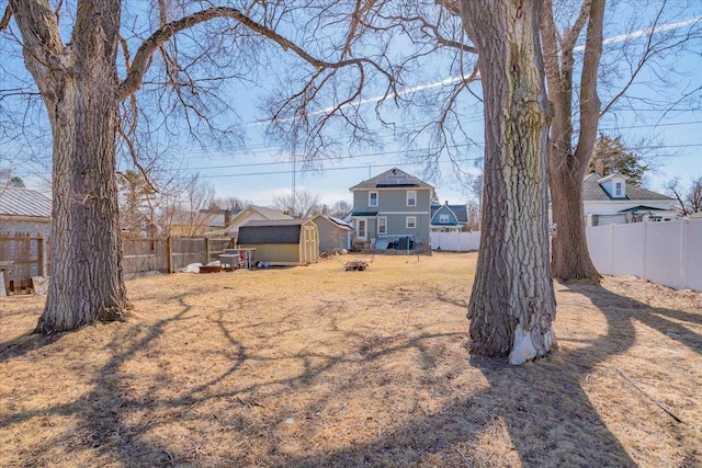 view of yard featuring a storage shed, an outbuilding, and a fenced backyard