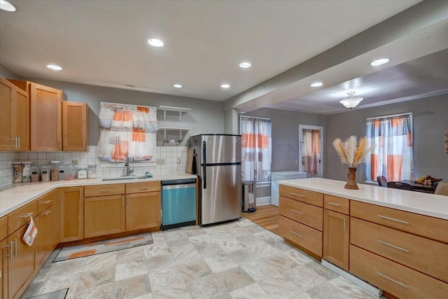 kitchen featuring dishwashing machine, freestanding refrigerator, a sink, light countertops, and backsplash