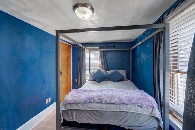 bedroom with baseboards and wood finished floors