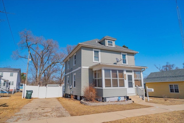 american foursquare style home with fence, central AC unit, and a sunroom