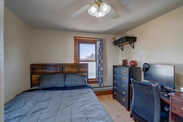 bedroom featuring light wood-type flooring, a baseboard heating unit, and ceiling fan