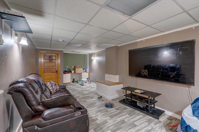 living area featuring wood finished floors, baseboards, and a paneled ceiling