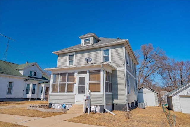 traditional style home with a storage unit, central AC unit, an outdoor structure, and a sunroom