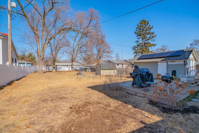 view of yard featuring an outbuilding, a playground, and a fenced backyard