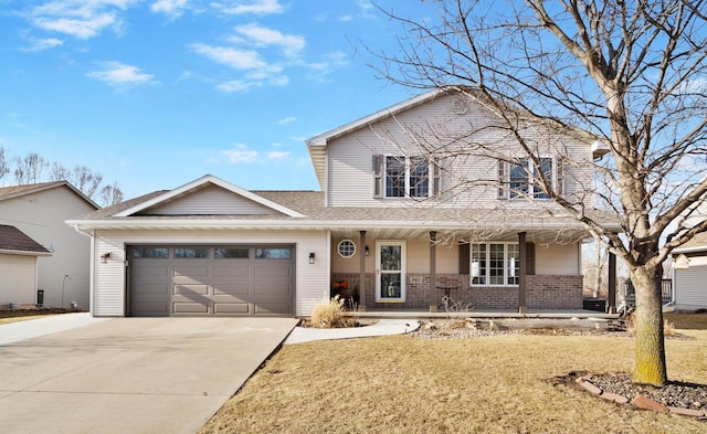 traditional-style house featuring a front lawn, driveway, a porch, an attached garage, and brick siding