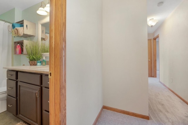 bathroom featuring baseboards, toilet, and vanity