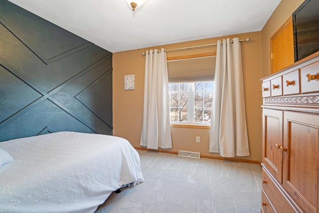 bedroom featuring visible vents, baseboards, and light colored carpet