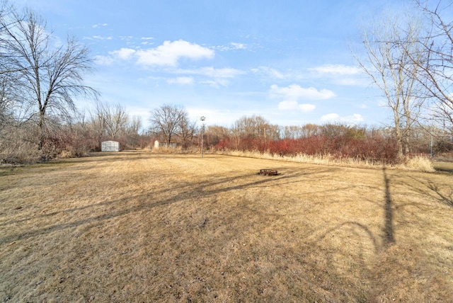 view of yard featuring a storage unit, an outbuilding, and a rural view