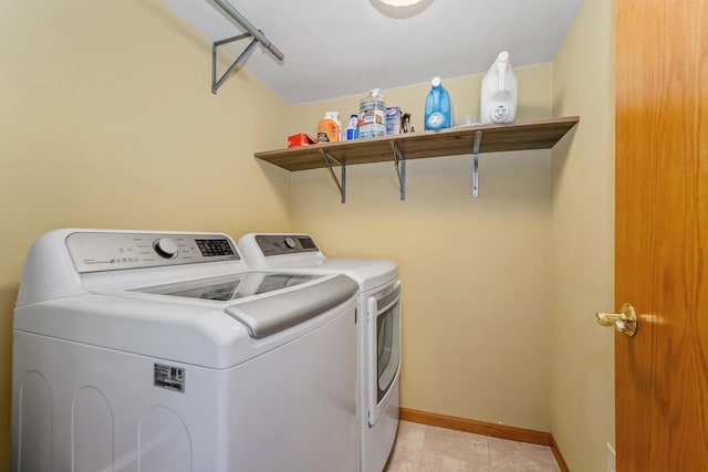 laundry area with washer and dryer, laundry area, light tile patterned flooring, and baseboards