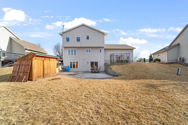 rear view of property featuring a patio, a lawn, and an outdoor structure