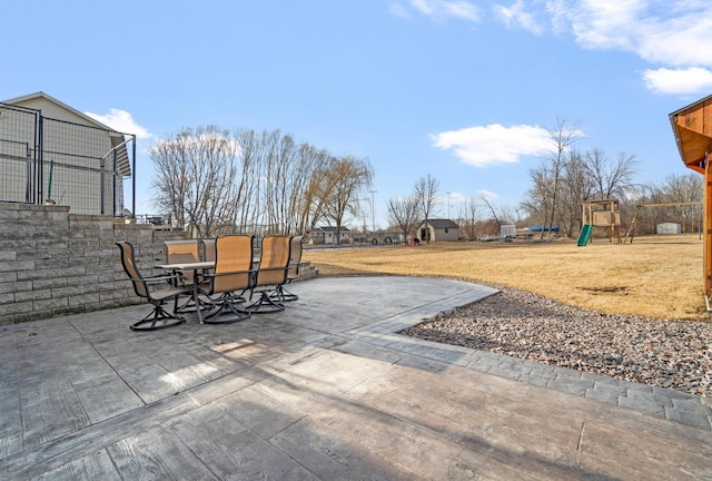 view of patio with playground community and outdoor dining space