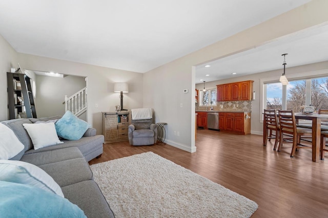 living area with recessed lighting, stairs, baseboards, and wood finished floors