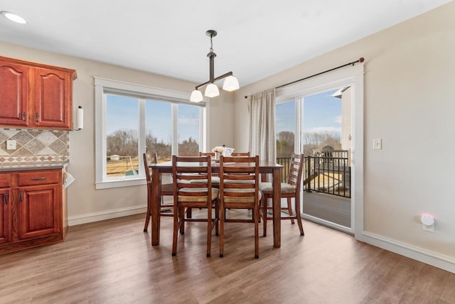 dining space with light wood finished floors, recessed lighting, and baseboards