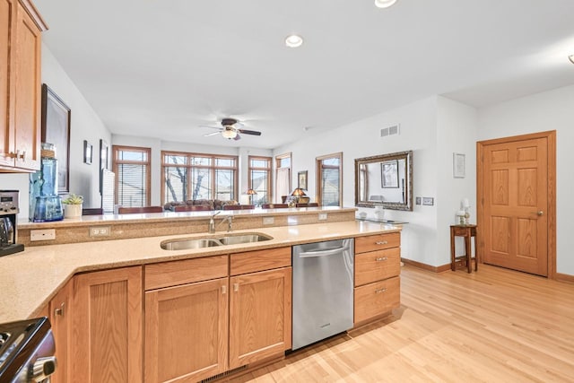 kitchen featuring visible vents, light wood-style flooring, stainless steel appliances, a ceiling fan, and a sink