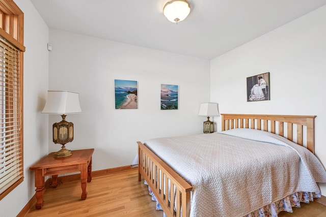 bedroom with light wood-style flooring and baseboards