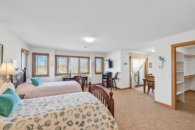 carpeted bedroom featuring a spacious closet and baseboards