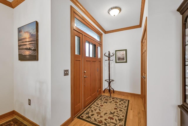 foyer entrance with crown molding, baseboards, and light wood-type flooring