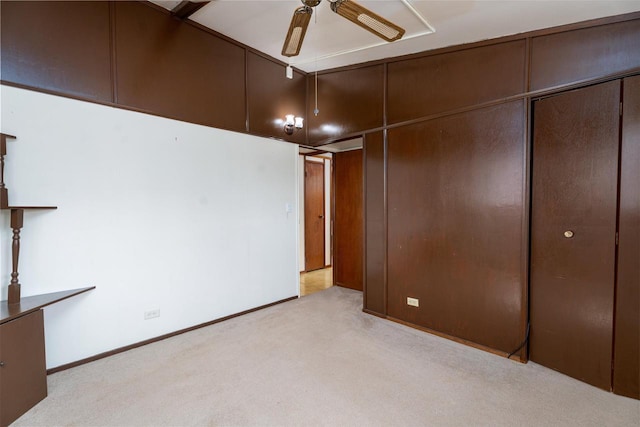 unfurnished bedroom featuring baseboards, a closet, and light carpet