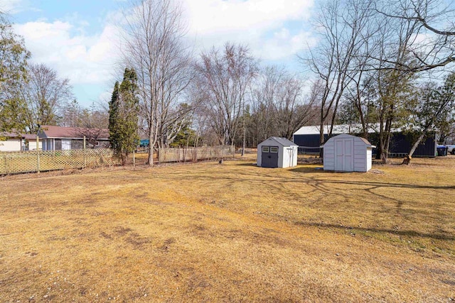 view of yard with a storage shed, an outdoor structure, and fence