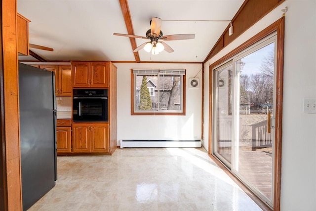 kitchen with black appliances, a ceiling fan, brown cabinetry, a baseboard radiator, and lofted ceiling