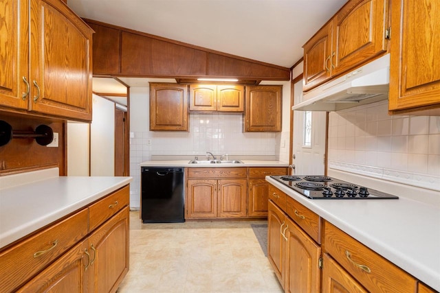 kitchen with under cabinet range hood, vaulted ceiling, brown cabinets, black appliances, and a sink