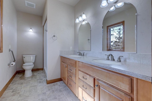 full bath with a sink, visible vents, toilet, and double vanity