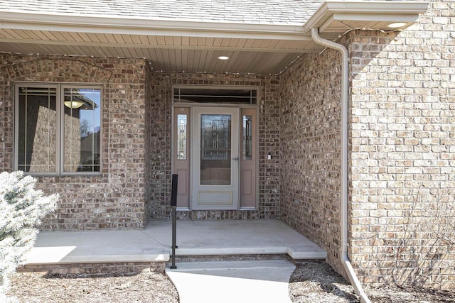 entrance to property featuring brick siding