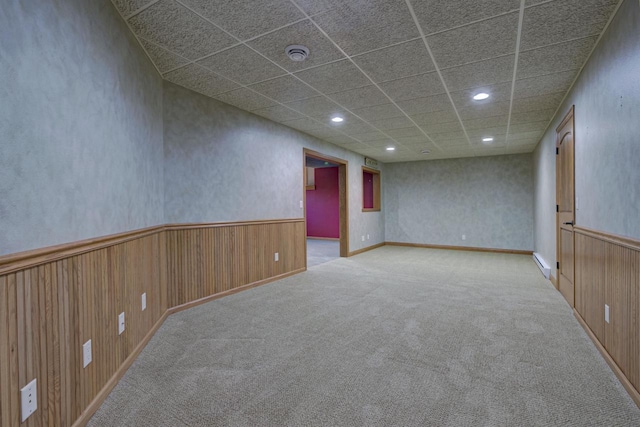 carpeted spare room with recessed lighting, a wainscoted wall, wood walls, and a baseboard heating unit