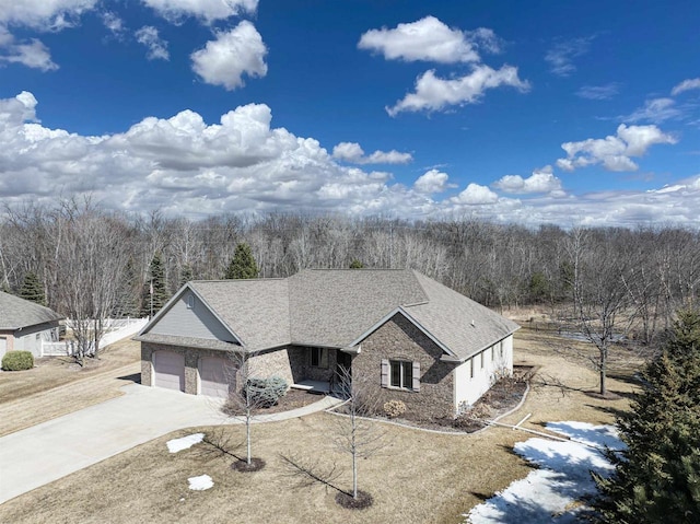 view of front of property with concrete driveway, a garage, and stone siding