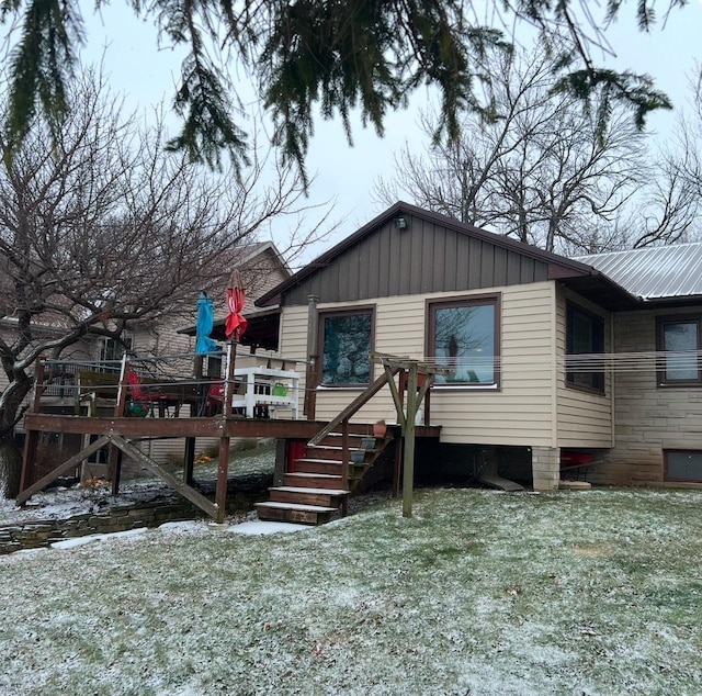 rear view of property with a deck, stairway, and board and batten siding