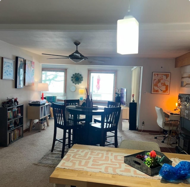 dining space with carpet, baseboards, and ceiling fan