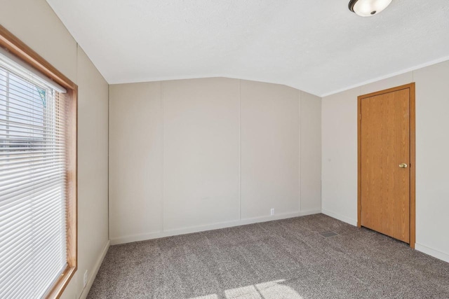 unfurnished room with lofted ceiling and carpet floors