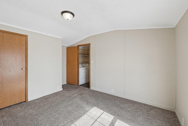 unfurnished bedroom featuring lofted ceiling, washer / clothes dryer, carpet, and baseboards