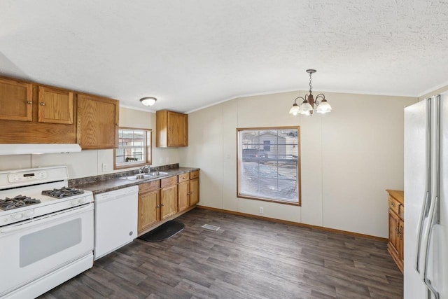 kitchen featuring a notable chandelier, a sink, a textured ceiling, white appliances, and dark wood-style flooring