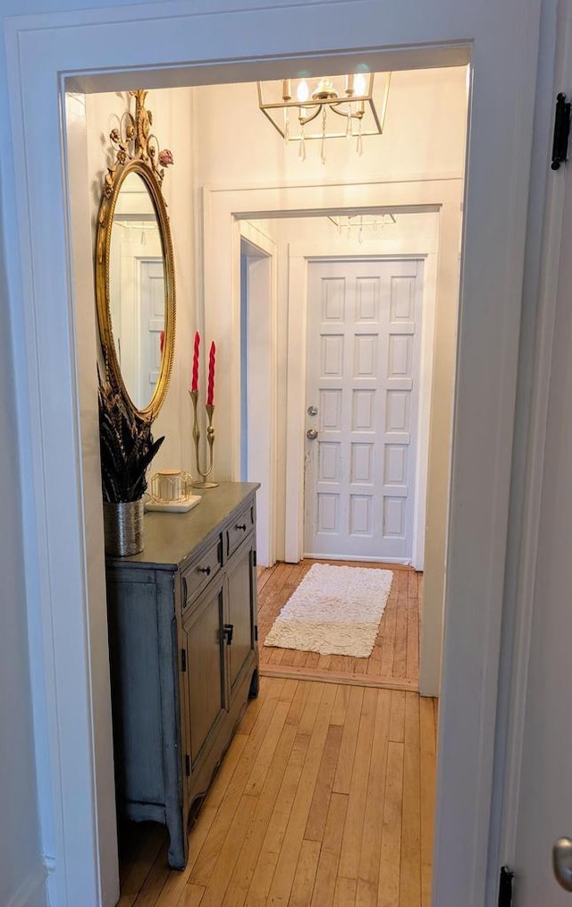 entrance foyer with light wood-style floors and a notable chandelier