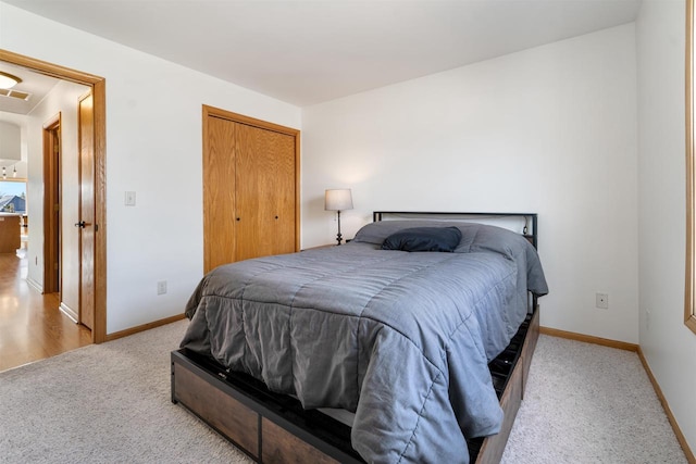 carpeted bedroom featuring a closet and baseboards