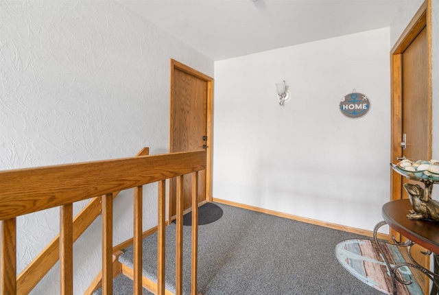 hall featuring baseboards and carpet flooring